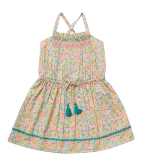 The Early Sunday Girls’ Alisson Dress is a sleeveless, floral mint dress for girls featuring a smocked bodice, teal tassel ties, criss-cross straps, and rickrack trim near the hem. This pastel summer dress is perfect for sunny days.