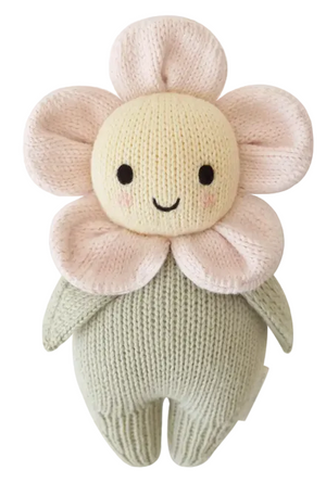 The Blush Pink Daisy - Baby 7" plush toy by Cuddle + Kind is a handcrafted, soft knitted flower featuring a yellow face, blush pink petals, a cheerful smile, and a green body—making it the perfect heirloom-quality keepsake for little ones.