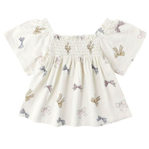 The Baby Girls' and Girls' Kate Top by Rylee & Cru features a smocked neckline and charming bows, bringing a sweet touch to this classic white top.