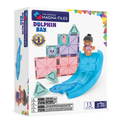 The Magnatiles Dolphin Bay 13-Piece Set features colorful magnetic tiles, a blue dolphin toy slide, and a child figure for creative play, designed for ages 3 to 99.