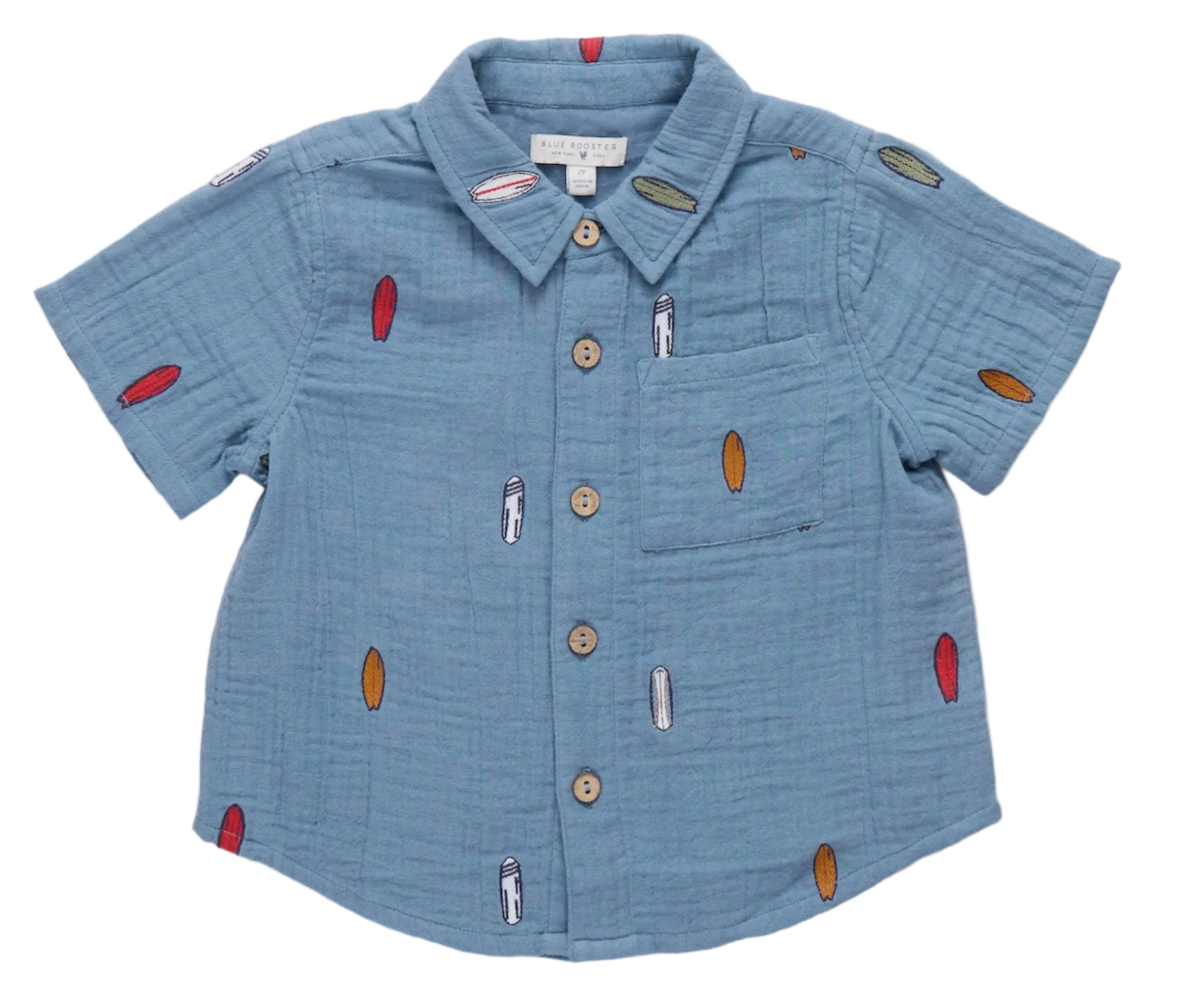 Sure! Here’s the rewritten sentence using your product data: The Boys’ Jack Shirt by Pink Chicken is a light blue, short-sleeve button-up featuring a chest pocket and a playful pattern of small, colorful surfboards, finished with natural wood buttons—a true warm-weather classic.