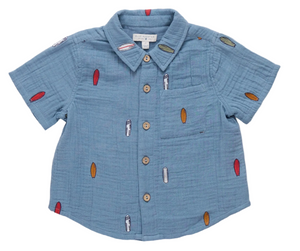 Sure! Here’s the rewritten sentence using your product data: The Boys’ Jack Shirt by Pink Chicken is a light blue, short-sleeve button-up featuring a chest pocket and a playful pattern of small, colorful surfboards, finished with natural wood buttons—a true warm-weather classic.