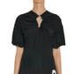 A person wearing the Lanvin Summer Top with Eyelet Detail, a black viscose jersey short-sleeve design featuring pleated sleeves and a metal-accented keyhole neckline.
