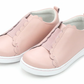 The Girls' Phoebe Slip On Sneaker by L'Amour Shoes is a light pink toddler sneaker with scalloped edges, elastic bands, white soles, and a comfy leather sockbed.