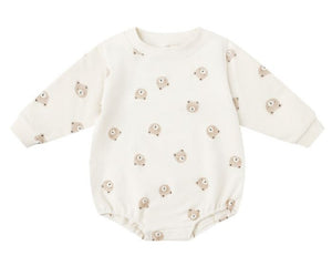 The Quincy Mae Baby Crewneck Bubble Romper features cream-colored French terry, long sleeves, and a cute cartoon bear face pattern—ideal for your baby's transitional wardrobe.