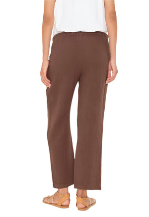 A person is shown from the back wearing a white top, tan sandals, and Xirena's Ozzie Pant—a cropped pull-on style with an elasticized drawstring waist.