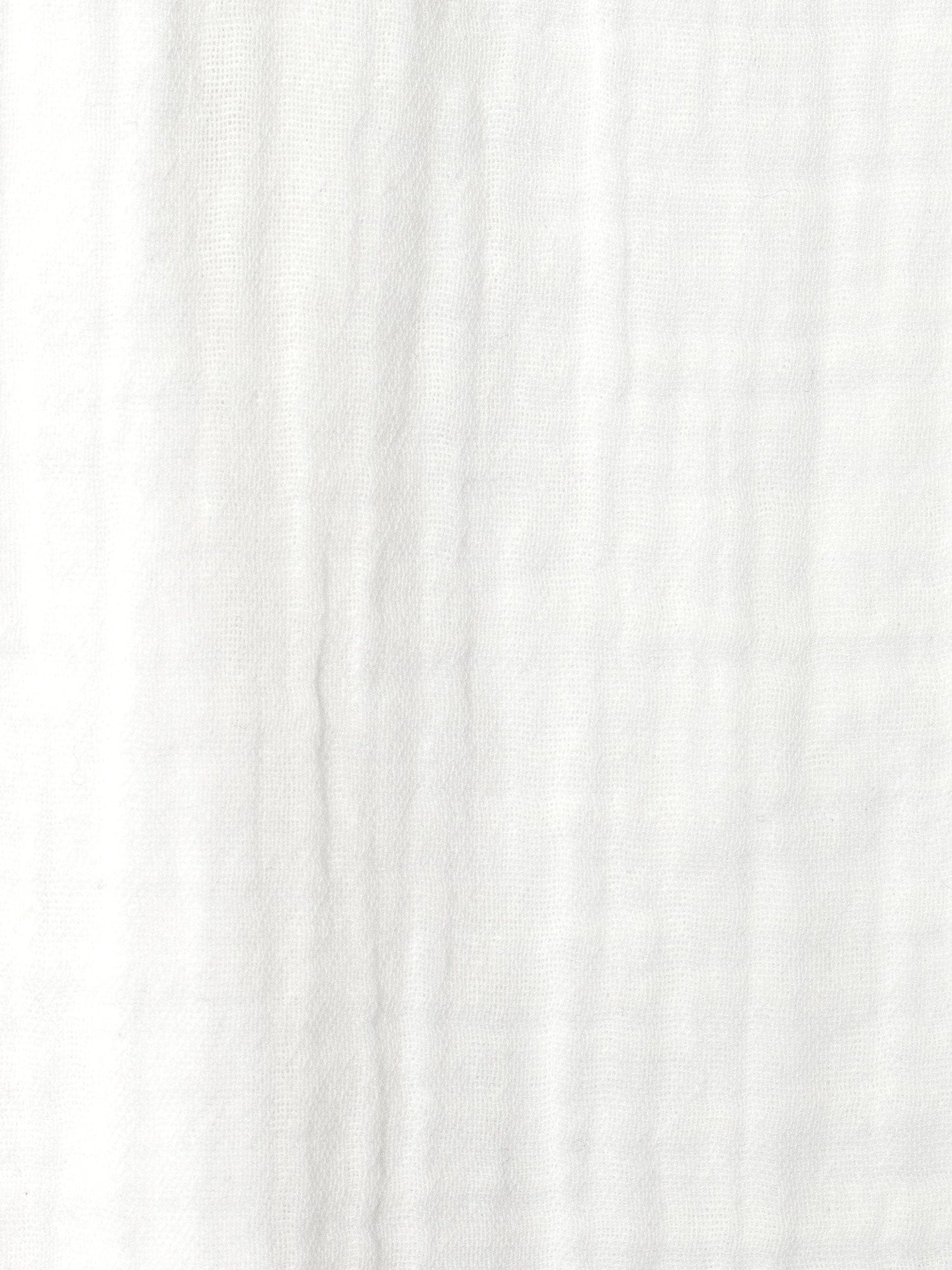 Close-up of the Andrea Dress by Xirena shows white textured fabric with visible vertical and horizontal creases, giving it a softly wrinkled look typical of cotton gauze.