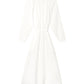 The Andrea Dress by Xirena is a white, ankle-length cotton gauze dress with long sleeves, a textured finish, gathered neckline, and a matching fabric belt at the waist.