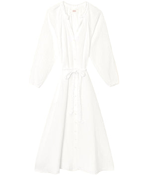 The Andrea Dress by Xirena is a white, long-sleeve, button-down midi dress featuring a cinched waist tie and soft textured cotton gauze fabric, shown laid flat on a white background.