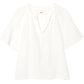 The Xirena Nia Top is a white cotton gauze popover blouse with short sleeves, a relaxed fit, round neckline, and partial button placket for easy, effortless style.