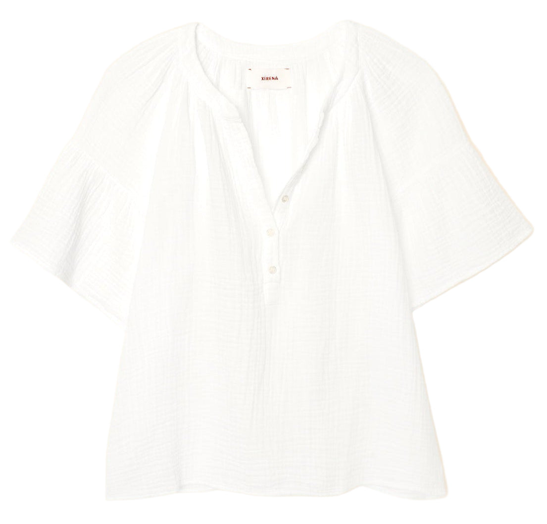 The Xirena Nia Top is a white cotton gauze popover blouse with short sleeves, a relaxed fit, round neckline, and partial button placket for easy, effortless style.