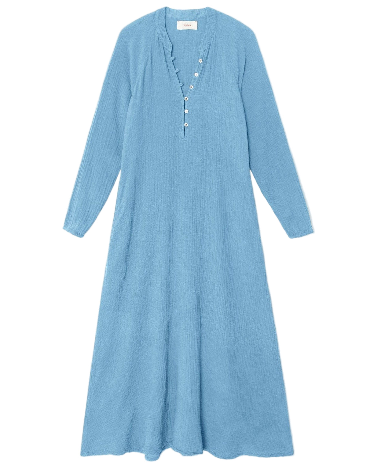The Xirena Tabitha Dress is a light blue cotton gauze midi with long raglan sleeves, a buttoned placket, and a flowy, loose fit, shown on a white background.