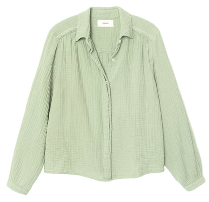 The Julianne Shirt by Xirena is a light green, long-sleeve button-front shirt with a textured fabric, collar, and subtle braided trim, shown laid flat on a white background.