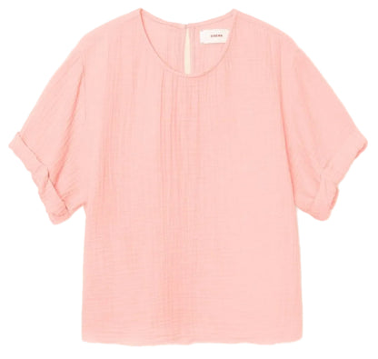 The Carson Top by Xirena features a light pink washed cotton gauze, short cuffed sleeves, scoop neck, subtle front pleats, and back button closure for a refined touch.