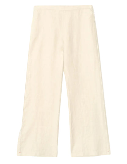 The Xirena Pippen Linen Pant features a wide-leg, high-waisted silhouette and an elasticized waist, shown here in cream linen laid flat on a white background.
