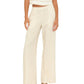A person wearing the Xirena Pippen Linen Pant—cream-colored, wide-leg, lightweight linen with an elastic waist—paired with a sleeveless matching top and black sandals, stands against a white background.