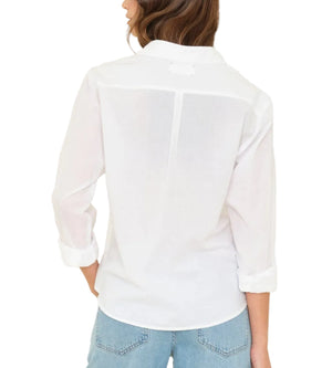 A person is shown from the back wearing the Xirena Bowie Shirt with rolled sleeves and light blue jeans, hair partly covering the collar for a modern look.