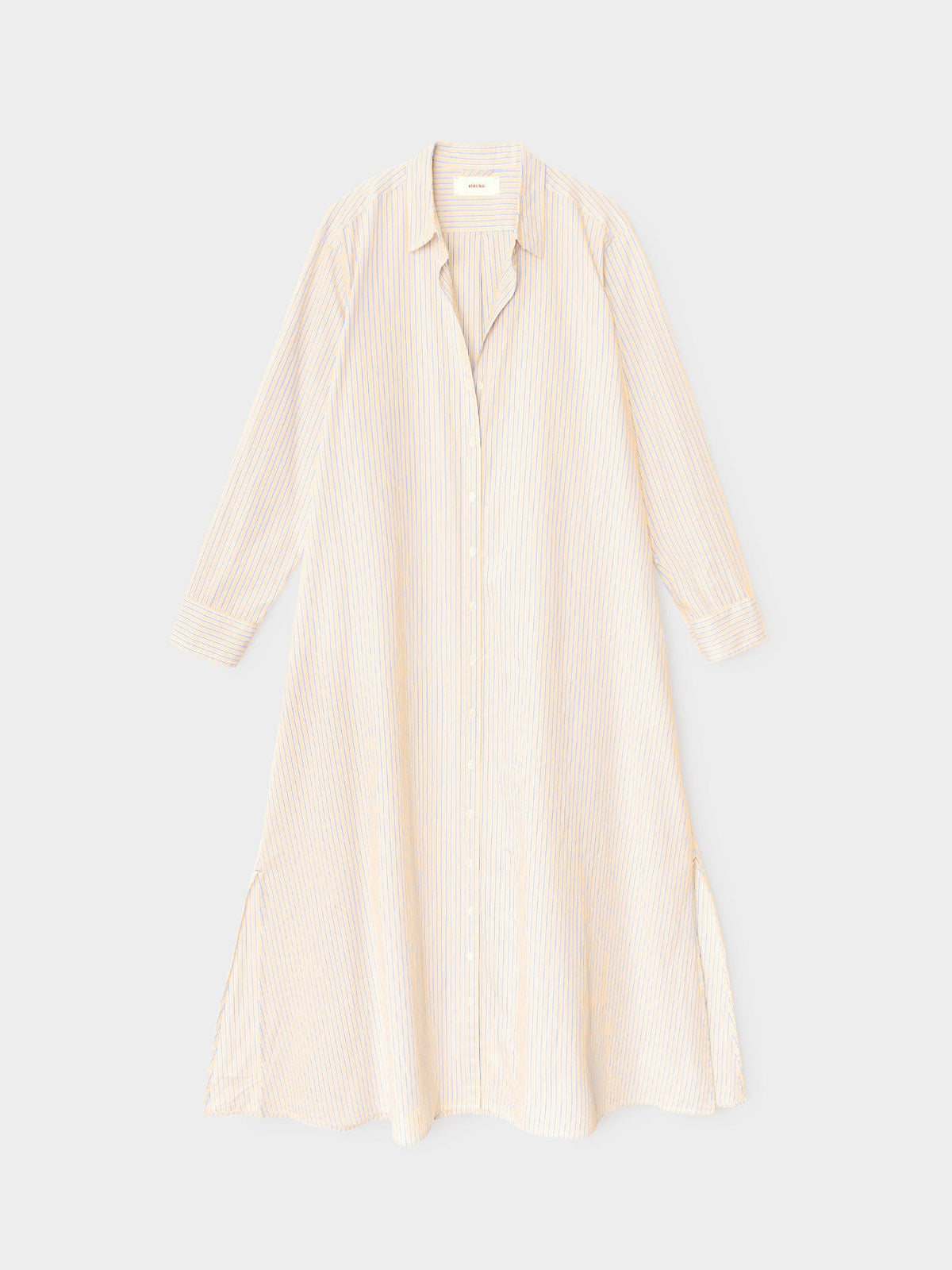 The Xirena Boden Stripe Dress is a lightweight cotton shirtdress with beige and white vertical stripes, long sleeves, button-front, collared neckline, loose fit, and side slits.