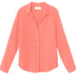 The Xirena Scout Cotton Gauze Shirt, a long-sleeved, coral button-front top with collar and shirttail hem made from double-faced cotton gauze, is shown laid flat on a white background.