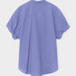 The Xirena Channing Cotton Poplin Shirt in light purple is shown from the back, featuring rolled-up sleeves, against a plain white background.