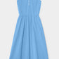 The Fallon Dress by Xirena is a sleeveless light blue midi made from lightweight cotton poplin, featuring a V-neckline, three bodice buttons, gathered waist, and full skirt.