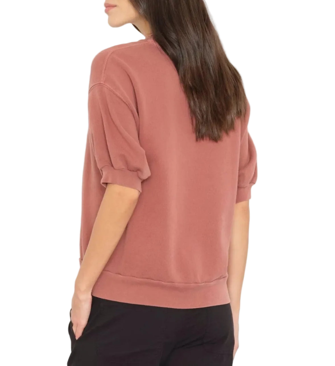 A woman wearing the Xirena Jax Sweatshirt, a vintage washed French terry short-sleeve top, and black pants stands with her back to the camera against a white background.