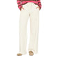 Wearing the Xirena Renzo Sweatpant—a cream-colored, wide-leg style with an elasticized drawstring waist—paired with tan shoes and a pink and brown striped long-sleeve shirt, hands in pockets, photographed from shoulders down.
