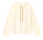 The Chase Sweatshirt by Xirena is a relaxed, off-white hoodie made from ultra-soft fleece, featuring beige-and-white braided drawstrings and a front kangaroo pocket, shown against a white background.