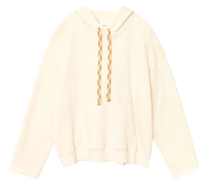 The Chase Sweatshirt by Xirena is a relaxed, off-white hoodie made from ultra-soft fleece, featuring beige-and-white braided drawstrings and a front kangaroo pocket, shown against a white background.