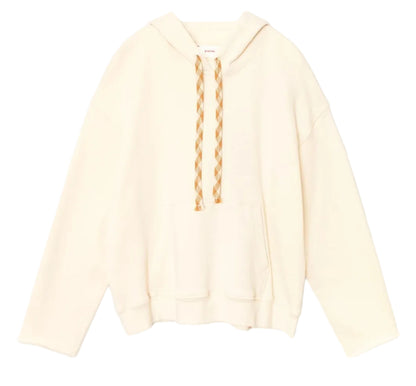 The Chase Sweatshirt by Xirena is a relaxed, off-white hoodie made from ultra-soft fleece, featuring beige-and-white braided drawstrings and a front kangaroo pocket, shown against a white background.