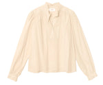 The Dorien Top by Xirena is a cream-colored, long-sleeve blouse crafted from lightweight cotton poplin, featuring a delicate ruffled collar, partial button front, and gathered blouson sleeves. It is displayed on a plain white background.