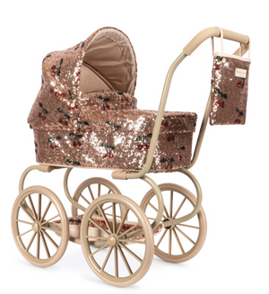 Konges Slojd Sparkly Minnie Doll Pram in a vintage style with rose gold sequins, a cherry print, large wheels, a foldable sun canopy, and a matching hanging bag.
