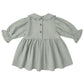 The Quincy Mae Baby Girls' and Girls' Marisol Dress features light grey fabric, a gathered skirt, wooden back buttons, and lace ruffle trim on the collar and sleeves.