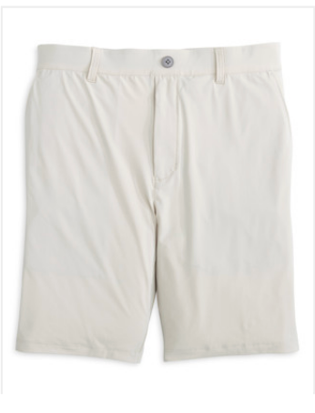 The Johnnie-O Fusionn Short is a light beige, knee-length chino style featuring belt loops, a front button closure, and a smooth finish with no visible pockets. Made from comfortable stretch-knit fabric, it is showcased against a white background.