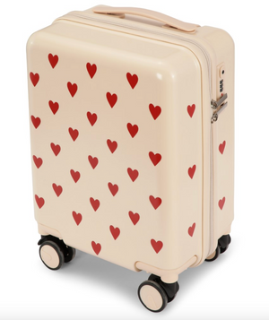 Cream-colored Konges Slojd Kids’ Travel Suitcase with a red heart pattern, featuring a top handle and a side TSA lock.