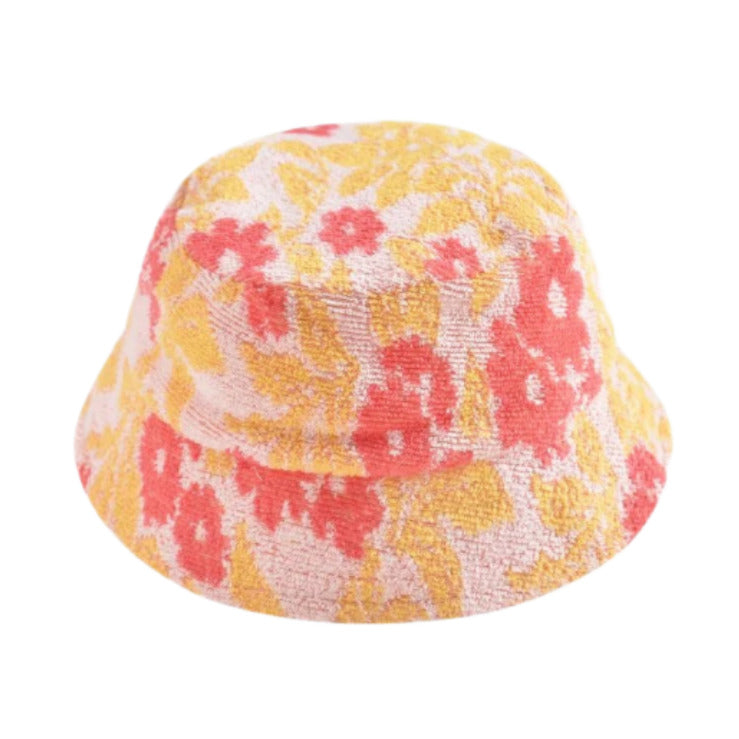 The Lajik Hat by Louise Misha is a jacquard sun hat with textured fabric featuring a yellow and orange floral pattern on a light background.