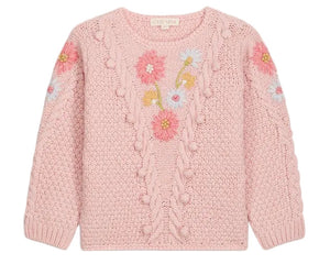 The Girls’ Acacia Sweater by Louise Misha is a light pink knit adorned with textured patterns and delicate handmade embroidery in shades of pink, blue, and yellow across the chest and sleeves, finished with playful pom-pom accents, displayed against a white background.