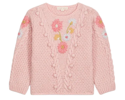 The Girls’ Acacia Sweater by Louise Misha is a light pink knit adorned with textured patterns and delicate handmade embroidery in shades of pink, blue, and yellow across the chest and sleeves, finished with playful pom-pom accents, displayed against a white background.