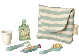 A charming Toothbrush Set in Blue Stripe Bag - Mouse by Maileg, featuring a tiny cup, shampoo bottle, toothpaste tube, toothbrush, and hairbrush—all in pastel colors—arranged on a white background.