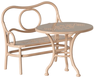 Big pale pink metal cafe set by Maileg, featuring a mouse-sized bench with curved backrest and a matching round table, both adorned with perforated floral patterns—a charming addition for relaxing at Mouse Hole Farmhouse.