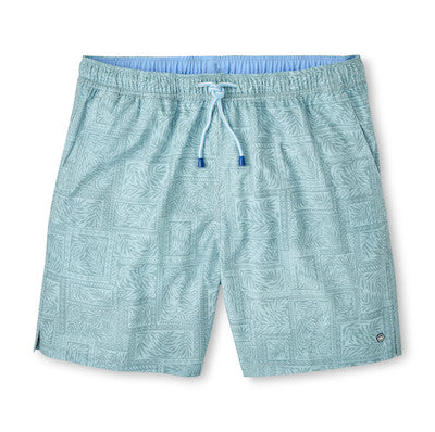 The Peter Millar Seaside Shade Swim Trunk features light blue fabric with palm leaf and geometric patterns, an elastic waistband, quick-dry material, drawstring, mesh liner, and side slit hems.