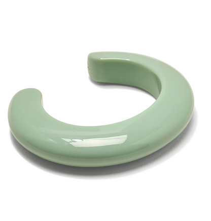 The Ridge Cuff by Lizzie Fortunato is a glossy, light green, C-shaped ceramic bracelet with a thick, smooth form, shown against a white background.