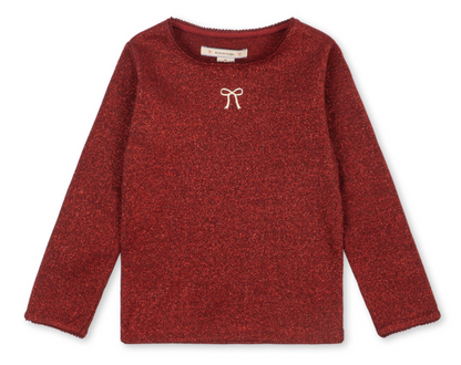 Girls’ Roli Blouse by Konges Slojd, a long-sleeved, glittery red knitted top with a small white bow detail at the neckline.