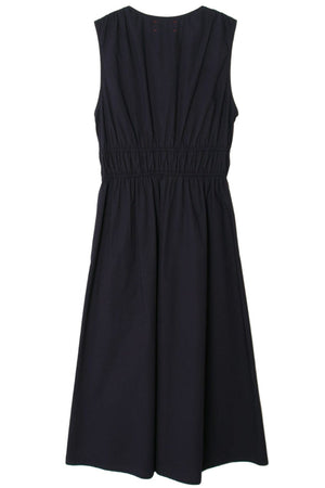 A sleeveless midi dress in navy blue cotton poplin, featuring an elastic waistband and pleated detailing at the top, displayed on a white background. This Xirena Cyra Dress is both stylish and comfortable.