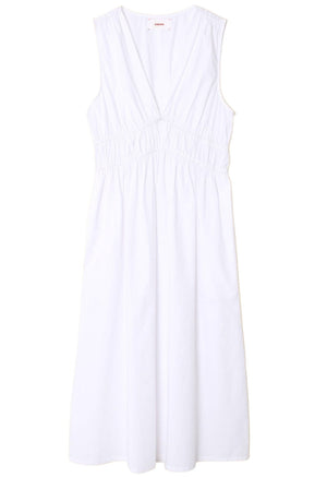 The Xirena Cyra Dress in white cotton poplin features a V-neck and gathered details at the waist, displayed on a pristine white background.