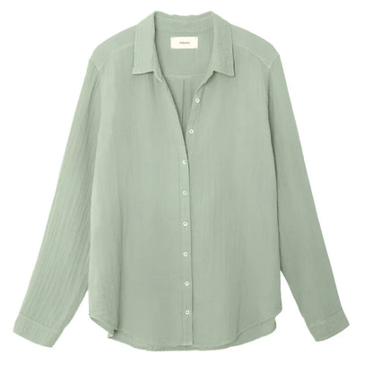 A light green Xirena Scout Shirt by Xirena, made from 100% cotton, featuring long sleeves and a button-up collar, shown against a plain white background.