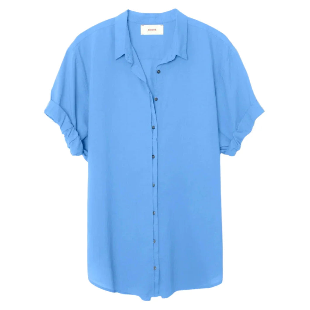 Introducing the Xirena Channing Shirt: a loose-fitting, short-sleeve button-up in light blue by Xirena. Crafted from lightweight cotton poplin, it exudes a boy-meets-girl attitude, making it perfect for any occasion. Displayed on a white background.