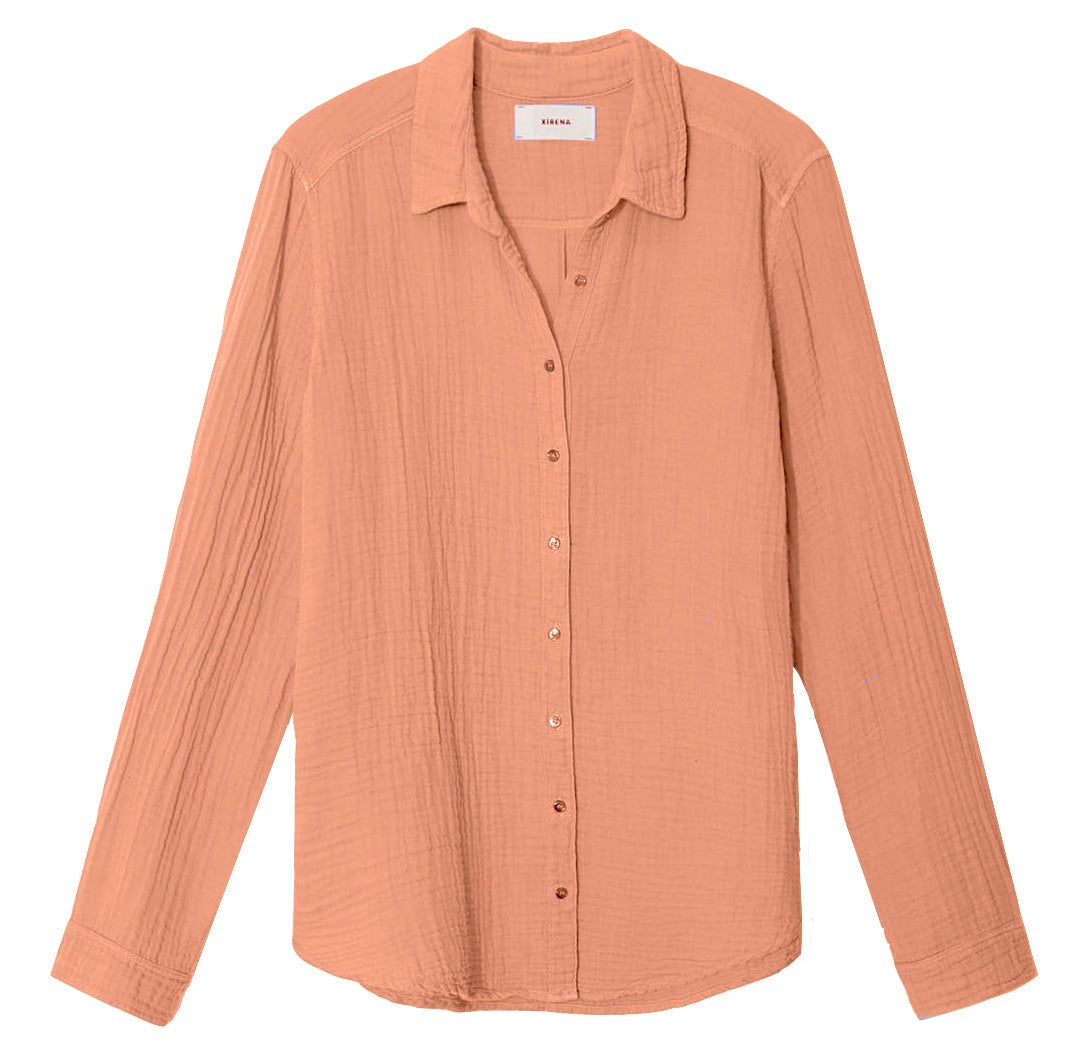 A peach-colored Xirena Scout Shirt button-up scout shirt with long sleeves and a pointed collar, displayed flat.