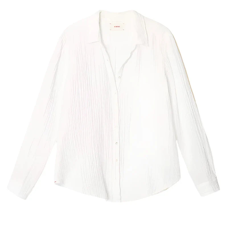 The Xirena Scout Shirt by Xirena is a long-sleeved white button-up shirt with a collar, featuring a subtle vertical pleated texture and crafted from 100% cotton.