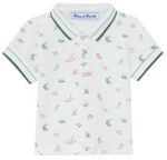 The Tartine et Chocolat Baby Boys’ and Boys’ Knitted Polo Shirt is a white short-sleeve polo crafted from soft cotton, featuring green trim, a small multicolored dinosaur pattern, a buttoned collar, and an inner label with the brand name.